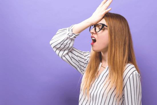 A woman slapping her forehead because she made mistakes in her video that is costing her views